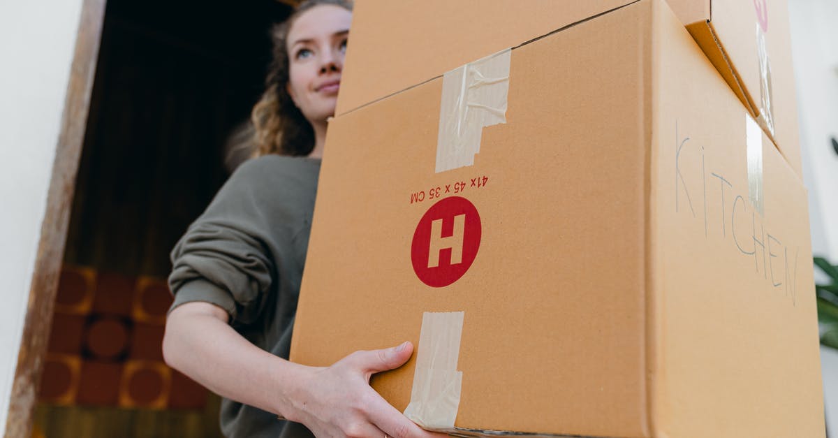 Obtaining a "Supervisa" for Canada from outside your home country? - Young female carrying cardboard boxes while moving out of house