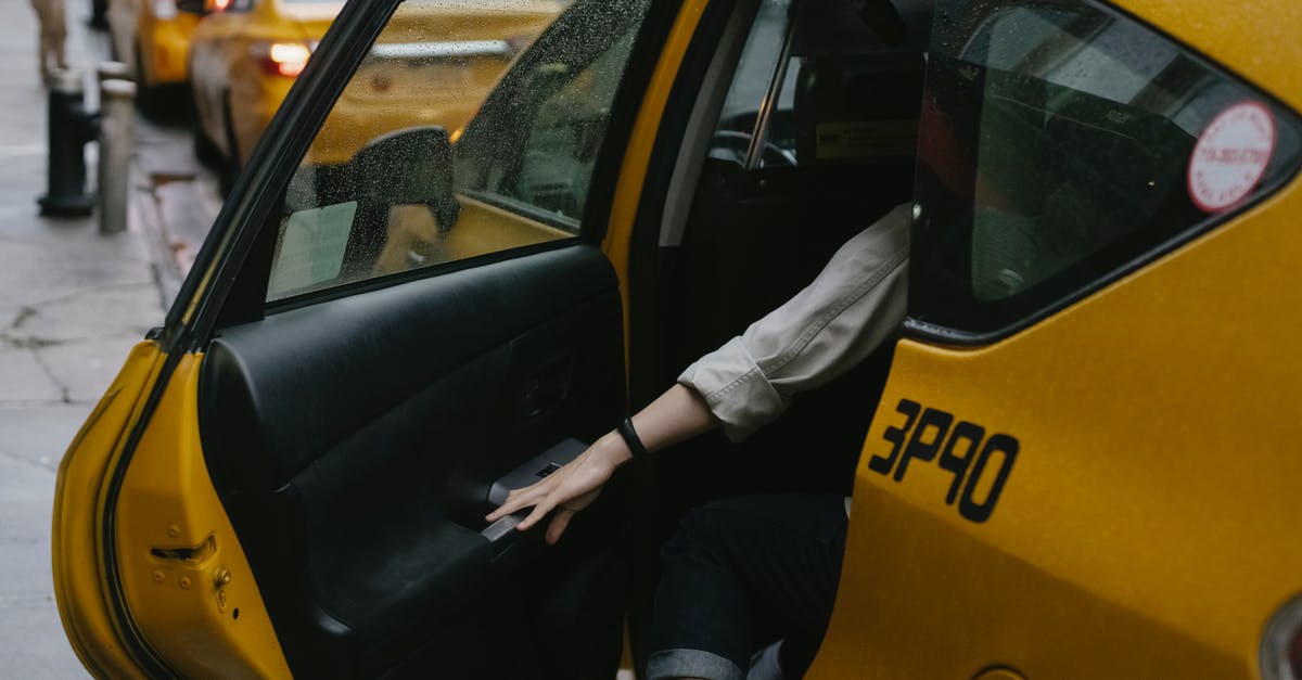 On street parking in the UK [closed] - Anonymous passenger closing door of cab parked on roadside with blurred cars on background in rush hour on street in city