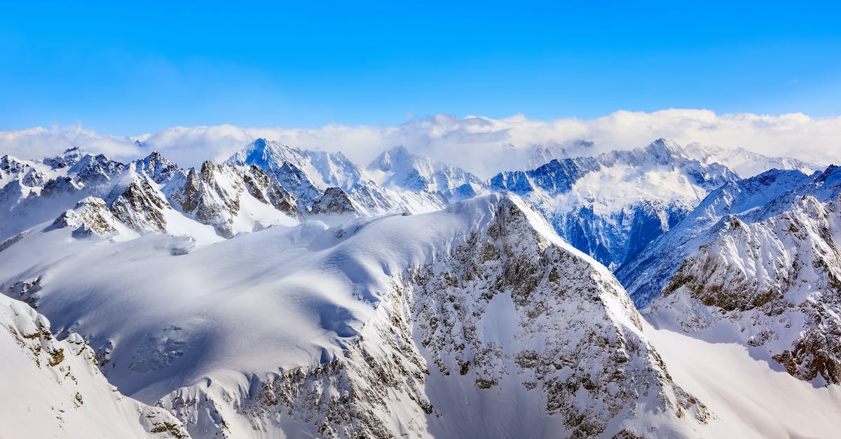 On the trail of the Alpine Ibex in Switzerland - Areal Photography Of Snow Coated Mountains Under Clear Blue Sky