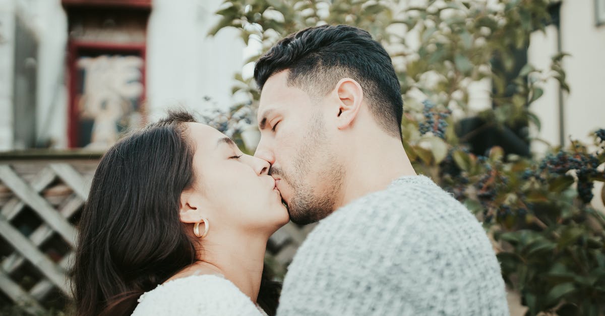 One day earlier than Earliest admission date | F1 OPT application [closed] - Side view of young couple in casual clothes standing in street together in summer day near green plants and building on background and kissing each other tenderly