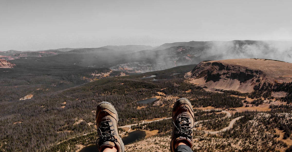 One person not traveling first leg of the journey - Crop hiker relaxing on mountain after achieving peak