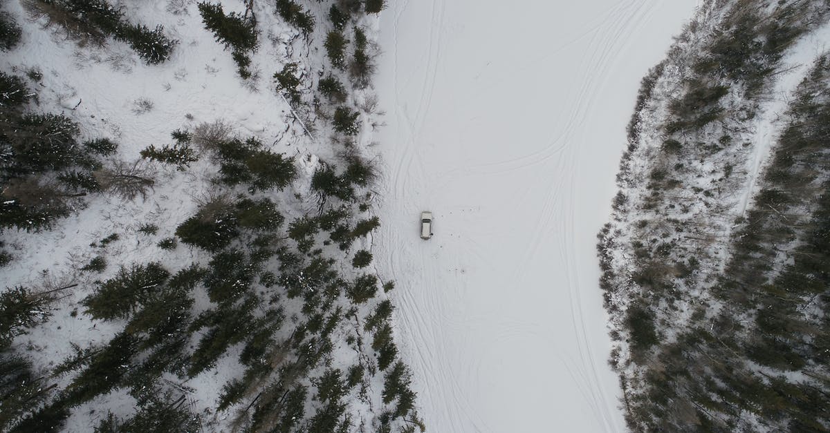 One way car rental between Las Vegas and North Rim Grand Canyon - Top view of car driving on snowy road going through forest covered snow in winter day