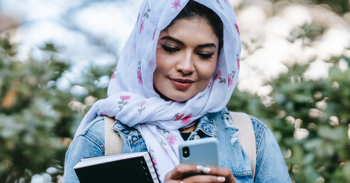 Online ticketing of National Express buses in UK - Cheerful Muslim woman with smartphone