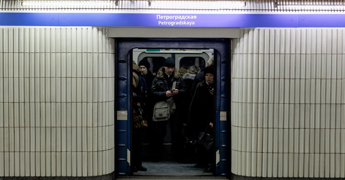 Open gates on the Paris Metro - Crop anonymous people in underground public transport against corridor with inscriptions under shiny light