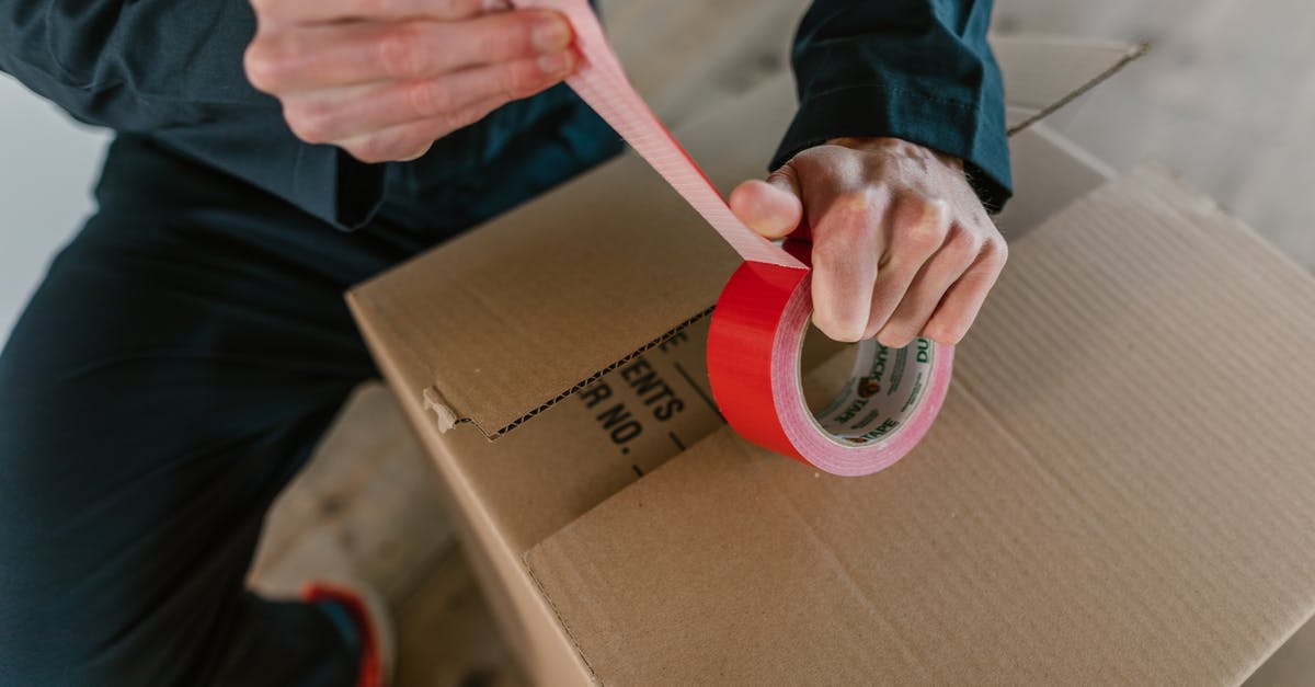 Optimal packing method for bras? - A Person Holding Red Packaging Tape