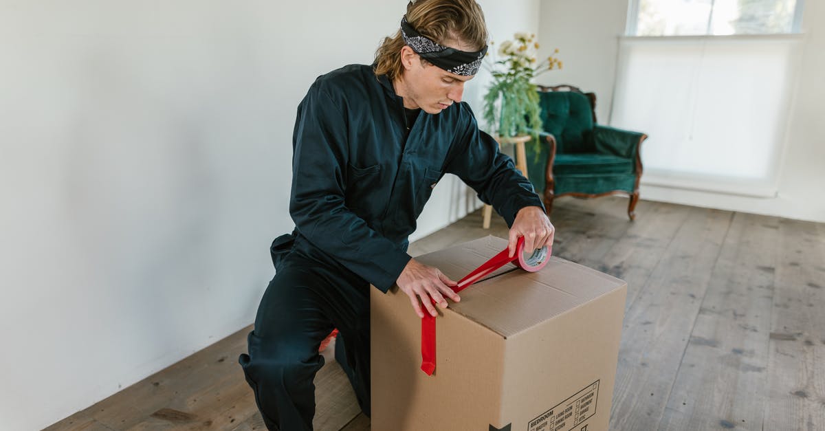 Optimal packing method for bras? - A Man Holding a Cardboard Box
