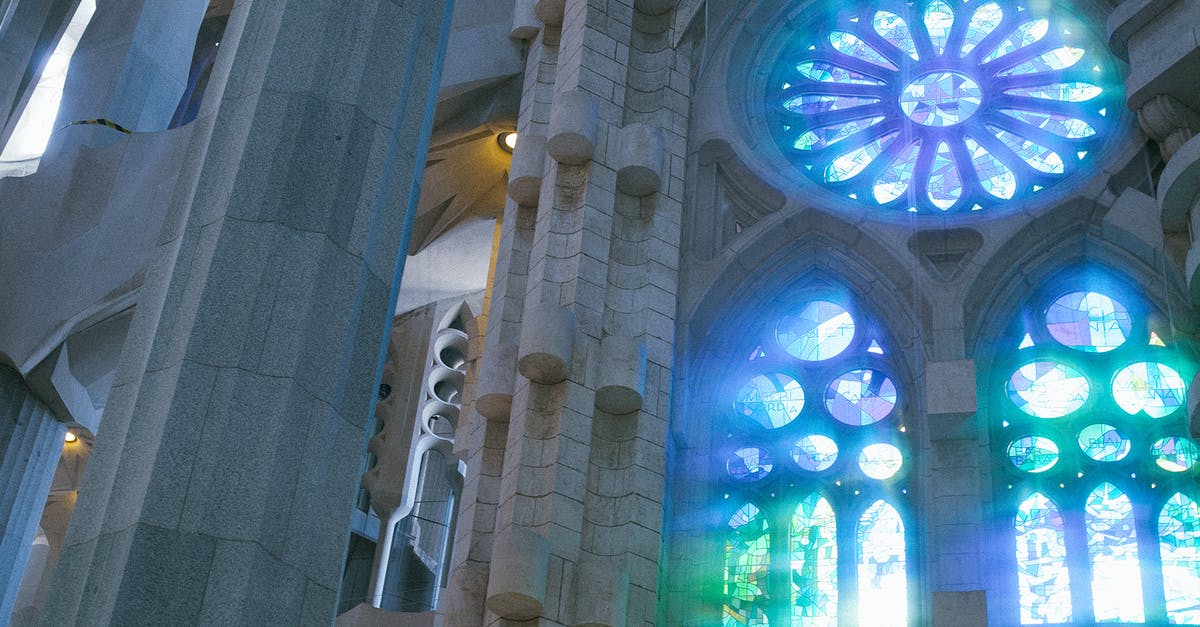 Optimum fares for transportations inside and around Barcelona (metro/trains) - Low angle of old catholic basilica with stained glass windows named Sagrada Familia located in Barcelona in Spain