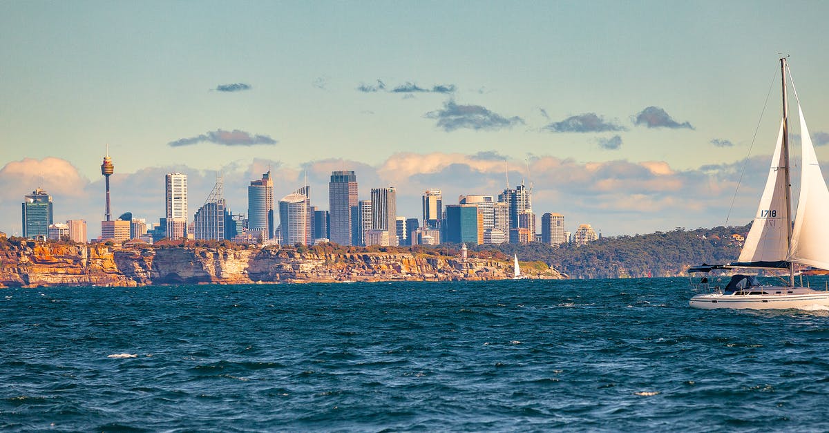 Options for getting around Sydney for Tourism - White Sail Boat Sailing on Body of Water Near City Buildings