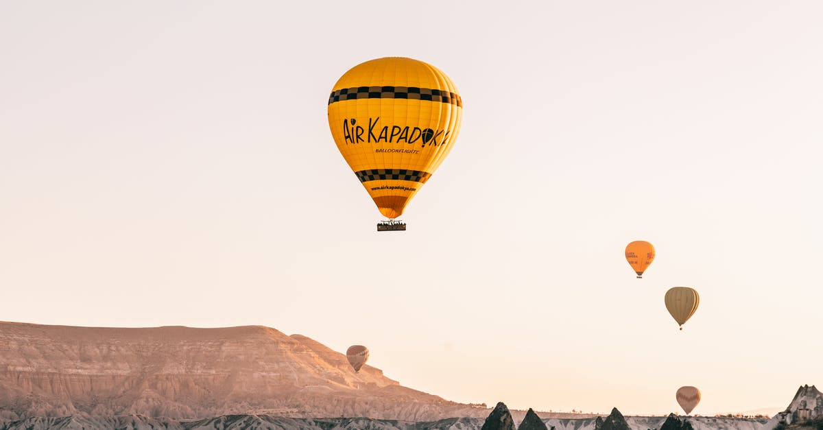 Options for getting from Kayseri (Turkey) to Goreme - From below of colorful air balloons flying over rocky formations in Goreme National Park located in mountainous valley against cloudless sundown sky