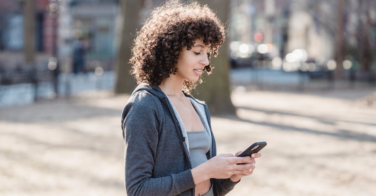 Options for sending a message while on a Shinkansen - Black woman using smartphone for sms in park