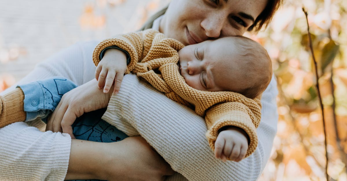 Options for sleeping at Heathrow during a long layover [duplicate] - Woman Hugging her Sleeping Baby