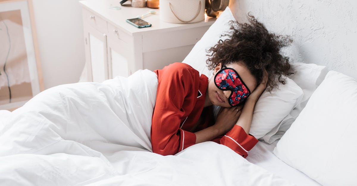 Options for sleeping at Heathrow during a long layover [duplicate] - Woman Wearing Eye Mask Lying on White Bed