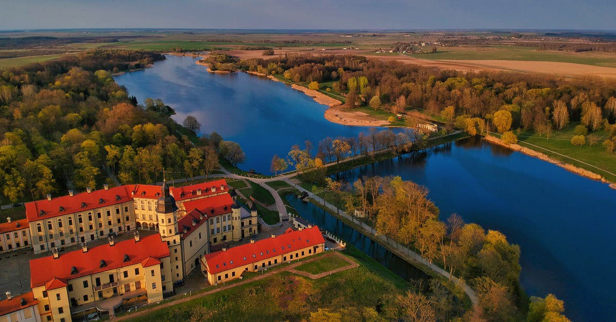 Options to travel from Moscow to Belarus and the EU on a foreign passport - Old castle on river shore in valley on autumn day