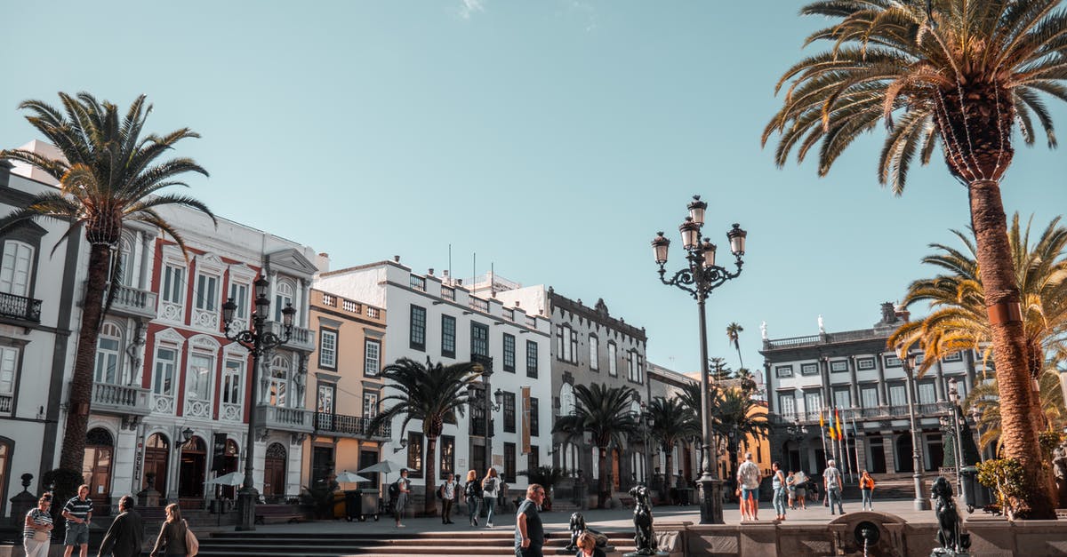 Overstayed tourist visa in Spain - People Standing and Sitting at the Open Park Near Buildings