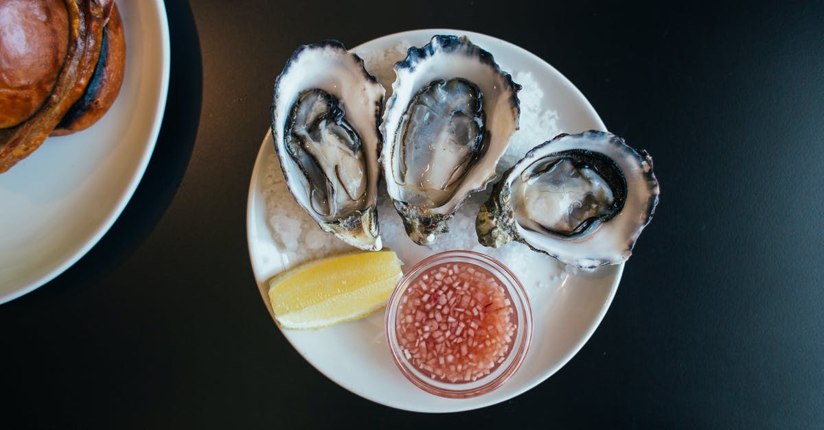 Oyster card—London only? - Top view of sophisticated seafood dish with oysters served on plate with sauce and lemon on table in modern restaurant