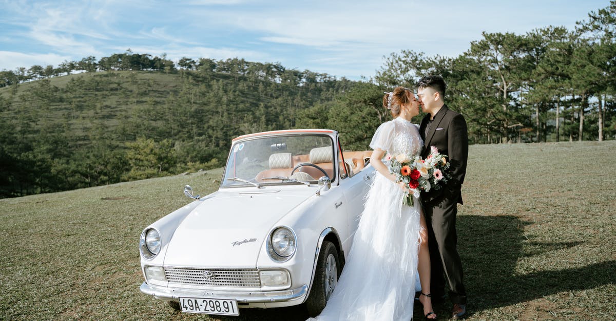 Park car near Paris [closed] - Young Asian couple kissing near retro car in hillscape