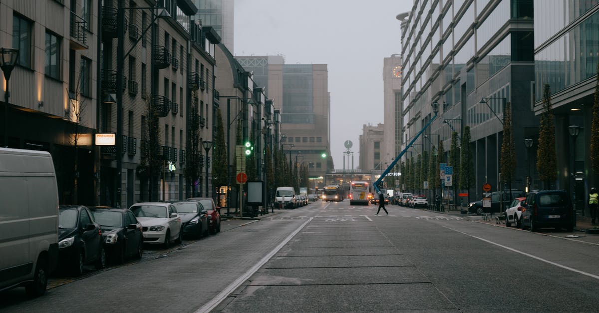 Parking in Belgium - Traffic on city road among buildings on overcast sky