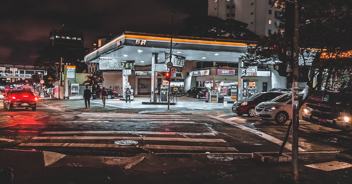 Parking in Venice in August - should I book a parking lot? - Cars driving down asphalt busy roadway with crossing near modern illuminated gas station