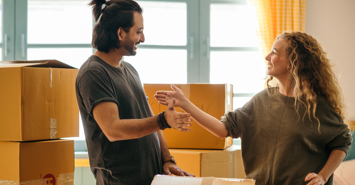 Passport renewal application package questions - Happy diverse couple among carton boxes in new home