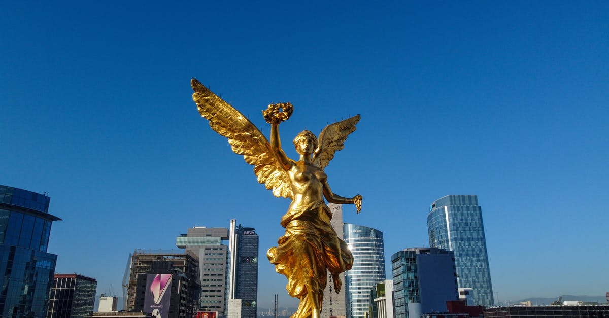 Passport stamped on arrival in Mexico, none departing Mexico - Gold Angel Statue Near High Rise Building