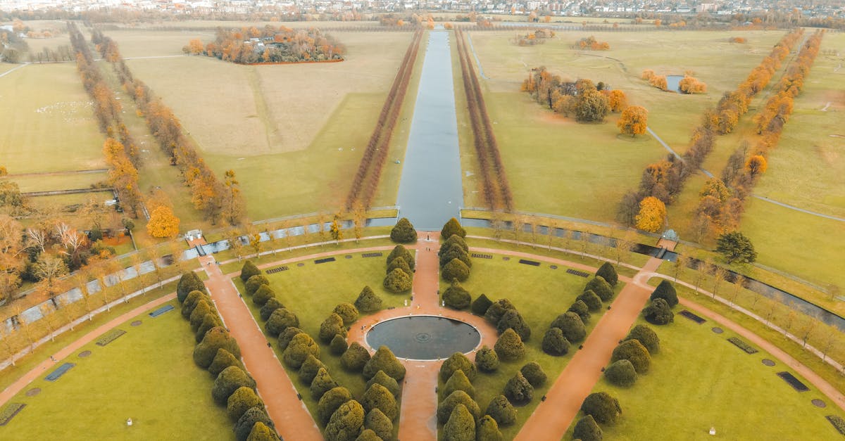 Passport stamps from london -ams-london - Picturesque aerial view of well groomed gardens and fountains of ancient historic Hampton Court Palace located in London