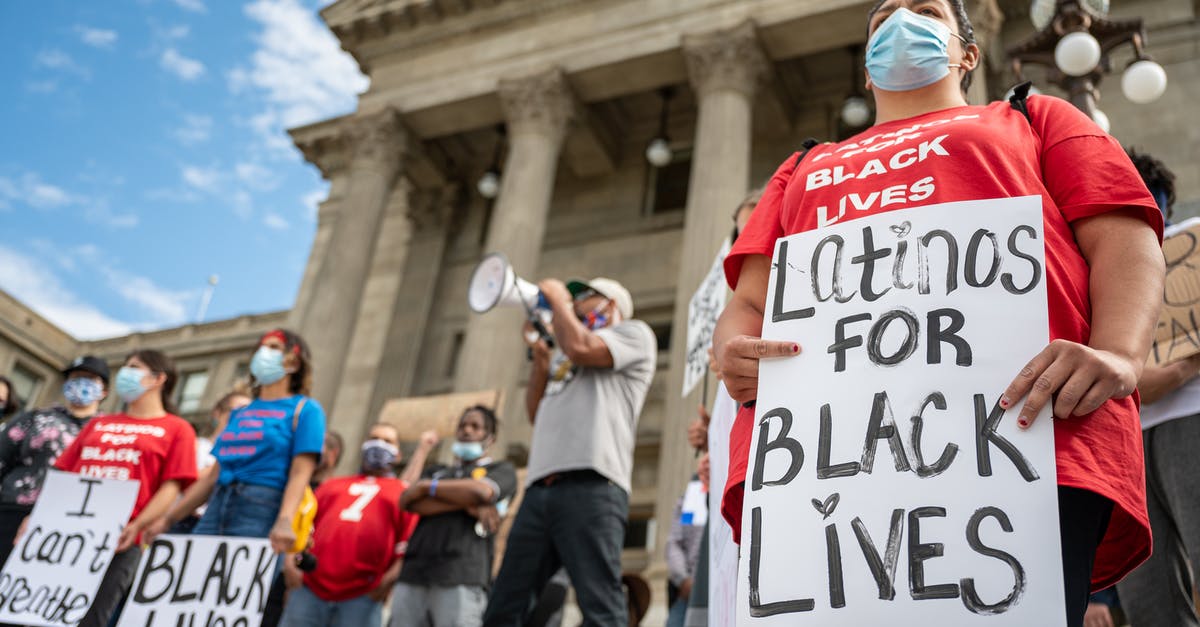 People exempt from Trump's COVID-19 proclamation, what is the quarantine/screening requirement? - Unrecognizable person with sign on protest