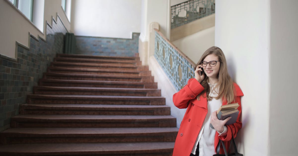 Phone Service while a student in Israel [closed] - Cheerful female student standing with books and handbag in university hallway near staircase and speaking on mobile phone with closed eyes while relaxing after lesson and leaning on wall