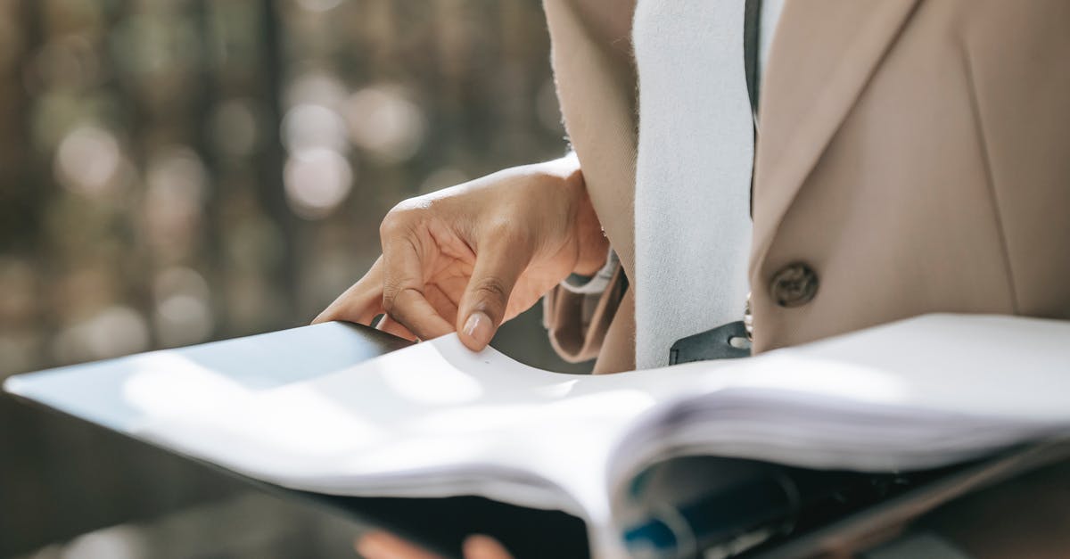 Photocopies of important documents stolen - Crop faceless female entrepreneur in stylish jacket reading important documents in black folder