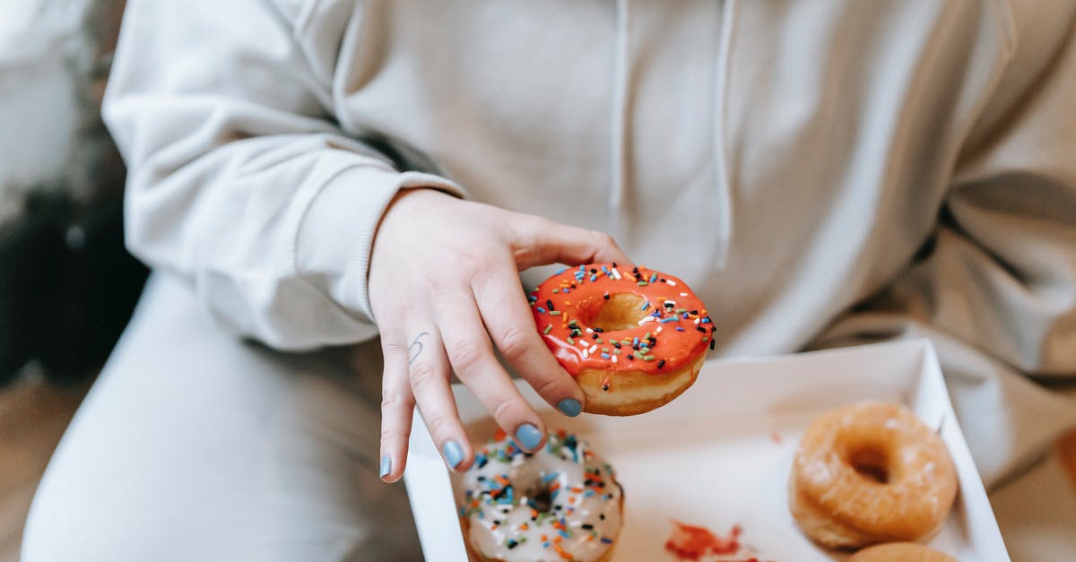 Pick up a package in the US sent from abroad - Crop faceless woman taking appetizing donut from box