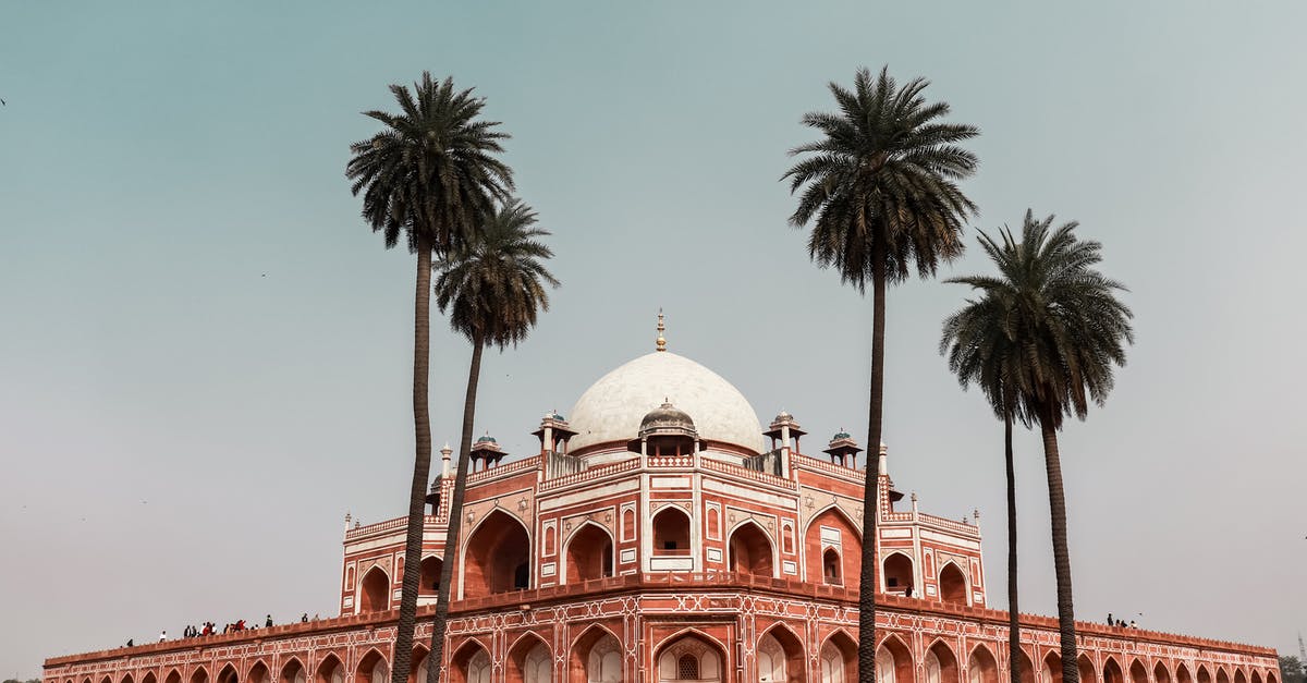Place for long stay in North India - Exterior of famous ancient building located in Delhi in India named Humayun Tomb in summer day under cloudless sky near tall exotic trees
