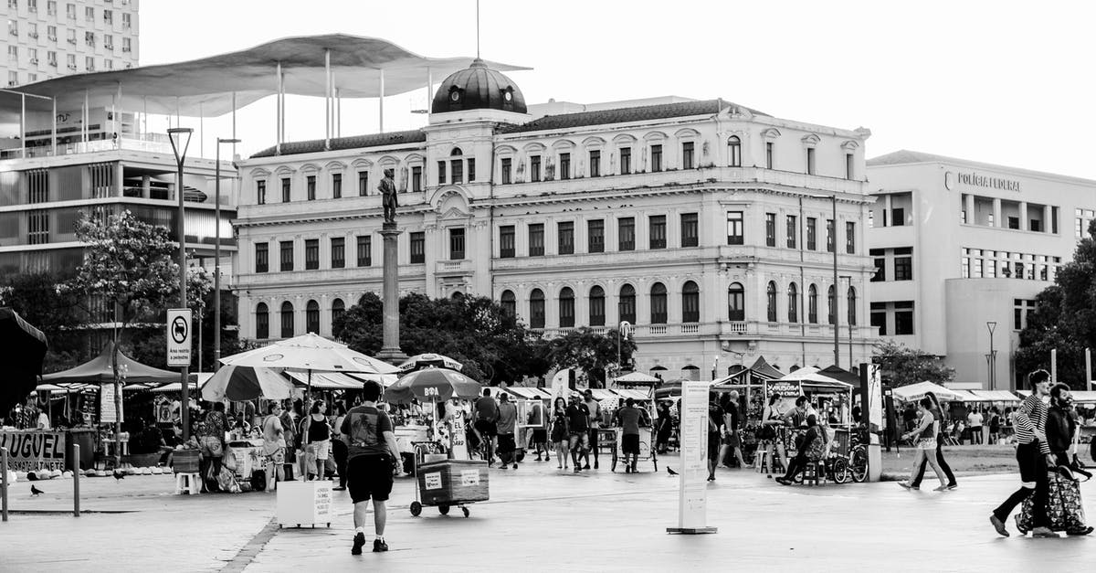 Place to store luggage for the day in Tokyo? - Square in centre of big city with big buildings and open market stalls and full of people in sunny summer day