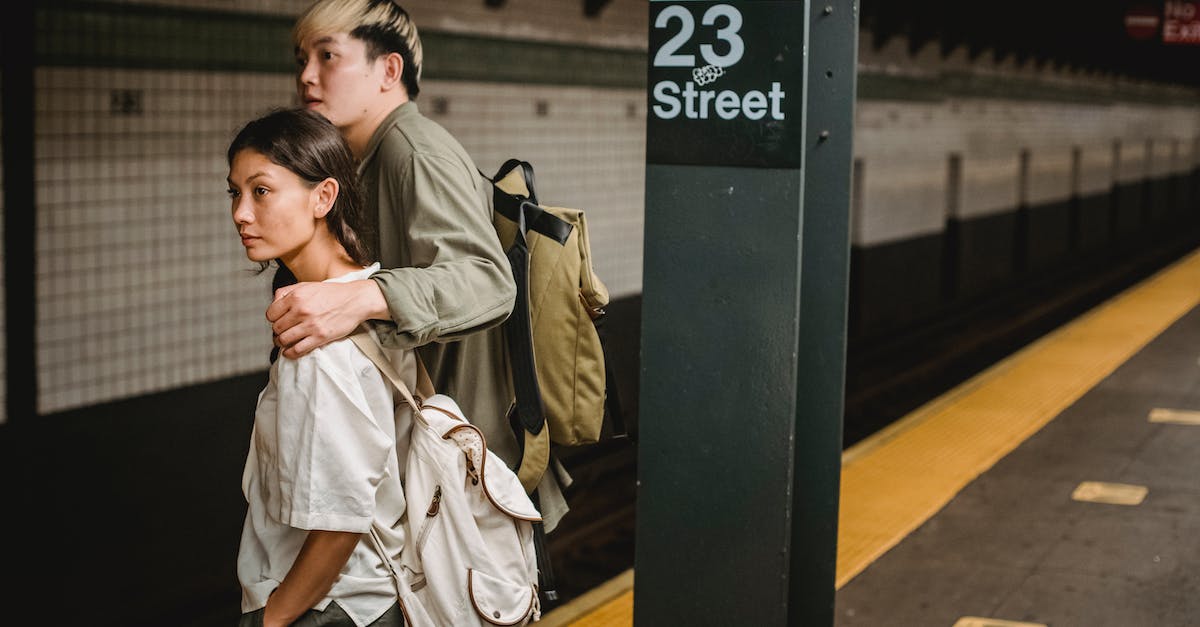 Places with unusual platform numbers - Man in Brown Coat Standing Beside Black Metal PostAsian Couple Waiting For A Train In A Subway Station