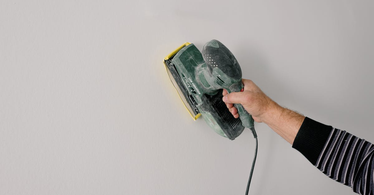 Polish Airports' fingerprint Process - Repairman polishing wall with construction tool