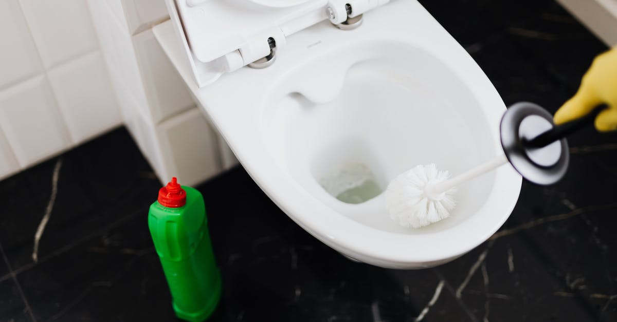 Polish Airports' fingerprint Process - From above of crop anonymous person in rubber gloves using liquid toilet sanitizer and brush to clean toilet bowl in bathroom