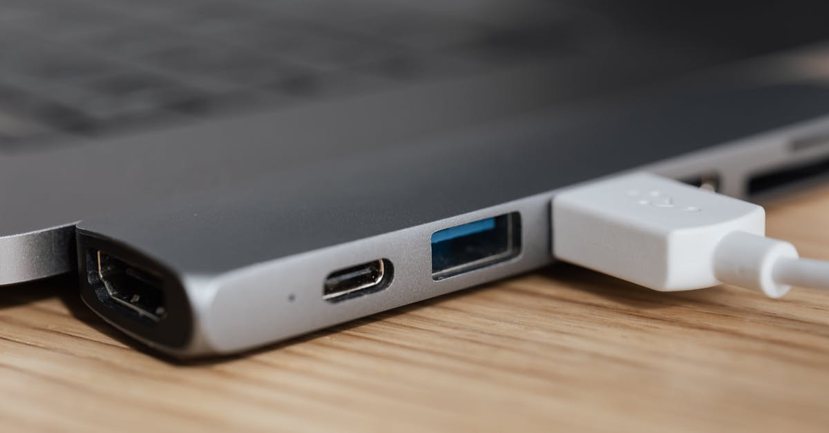 Power Adapter for travel: Grounding - USB type c multiport adapter with plugged white cable connected to modern laptop