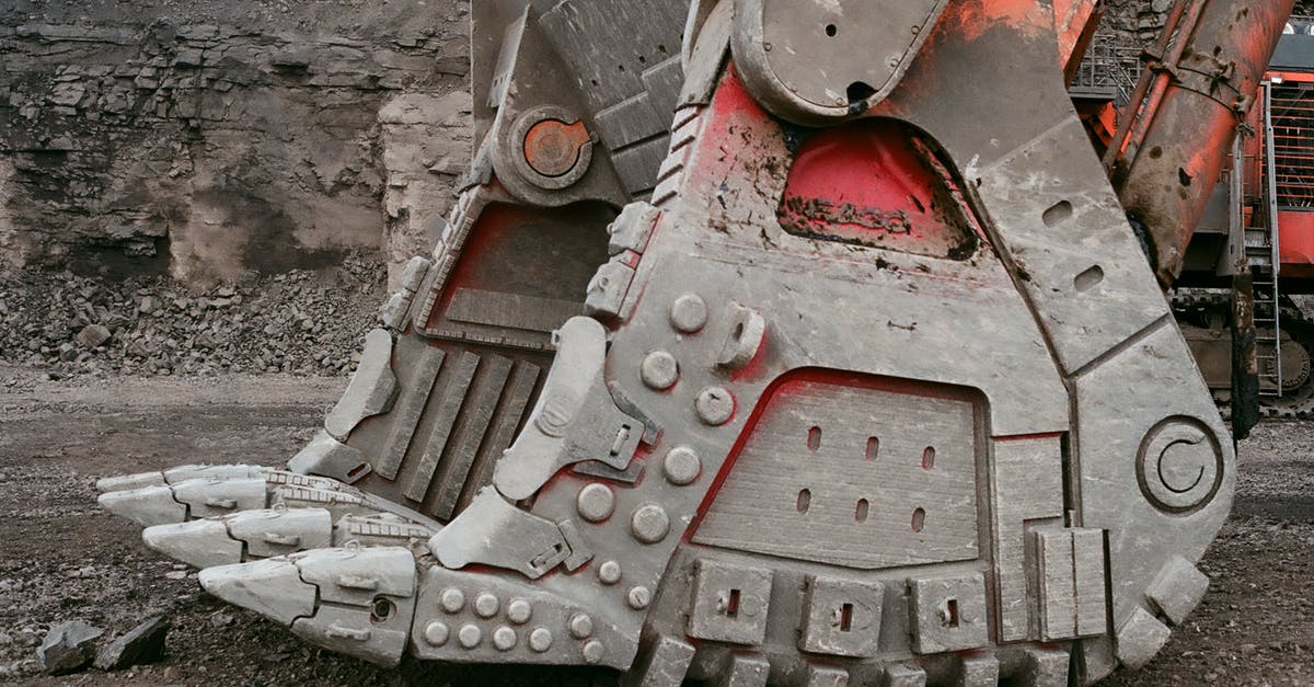 Power sockets in Ecuador - grounded or ungrounded? - Modern mining loader bucket for lifting heavy loads located on ground in quarry against gray stone wall on daytime