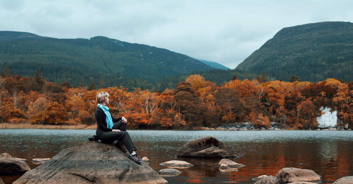 Precautions to take when travelling alone around Ireland - Woman Sitting on Rock Near River