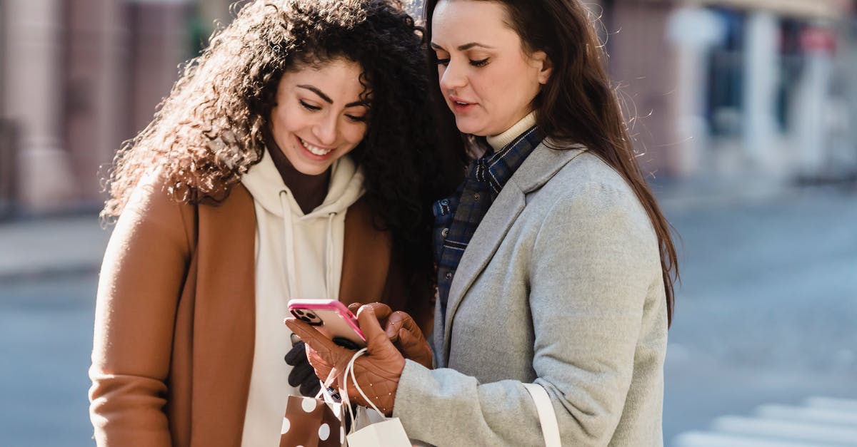 Prepaid mobile phone package for Frankfurt, Germany - Girlfriends in city street checking information on smartphone