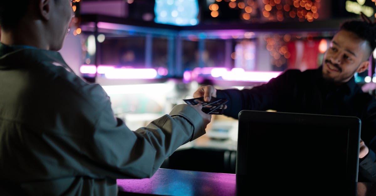 Price of self-transfer tickets versus separate tickets - Person in White Long Sleeve Shirt Holding Black Laptop Computer