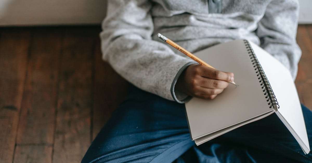 Primary occupation for the US visa - student or professional? - From above of African American schoolboy sitting on floor and writing with pencil in notebook