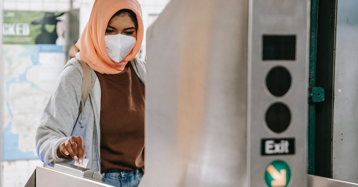 Problem at filling self declaration COVID – 19 Italy - Pensive Muslim female in mask applying card to turnstile