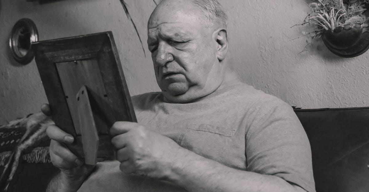 Problems with Canadian eTA - A Grayscale Photo of an Elderly Man Holding a Wooden Frame