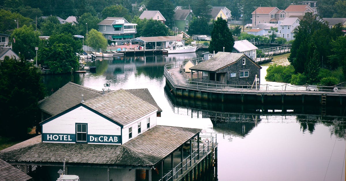 Procedure for traveling to the US on a green card - Cozy small residential houses located on shore of calm Tuckerton Seaport surrounded by green trees located in United States