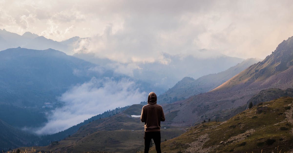 Procedure for traveling to the US on a green card - Person Wearing Brown Pullover and Black Jeans Standing on Mountain Top With The Scenic View