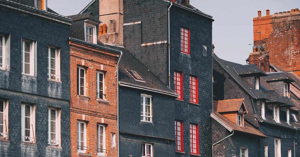 Proof of accommodation for France (travelling from India) [closed] - Low angle of aged shabby brick residential buildings with mansard windows against cloudy sky at sunset in Honfleur