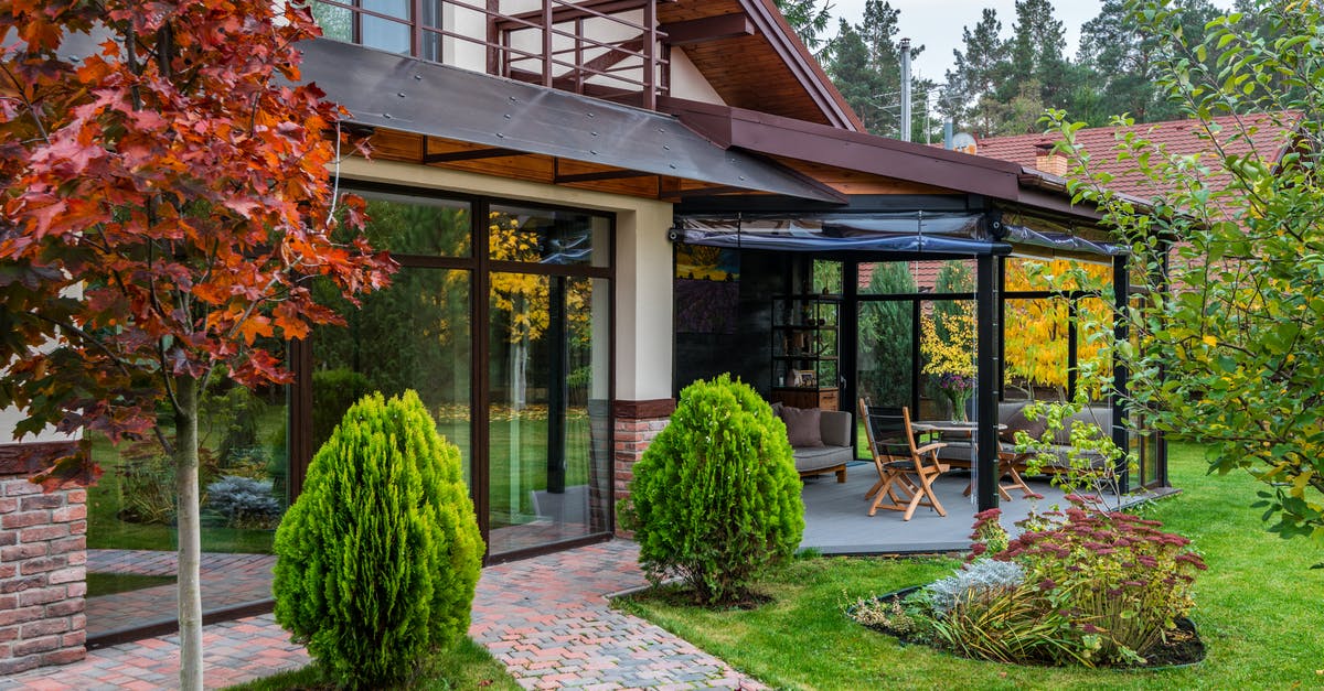 Proof of Accommodation in England - Exterior of contemporary house with cozy terrace and garden with bushes and trees on autumn day