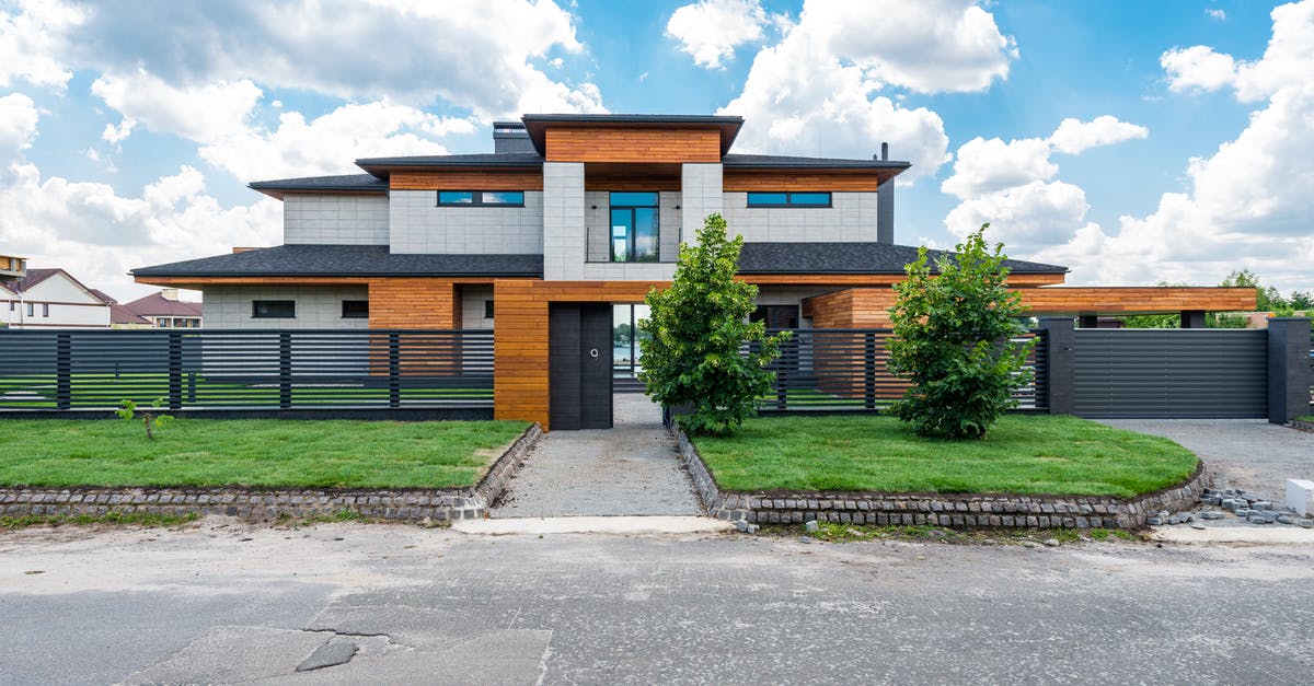 Proof of accommodation in UK for Schengen visa - Facade of contemporary luxury villa building with lawn and green trees under blue sky with clouds