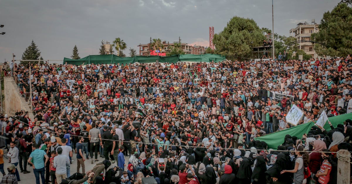 Public bus from Oruro to Sajama National Park [closed] - From above of overcast sky covered with clouds over trees in park next to crowd of demonstrators in daytime