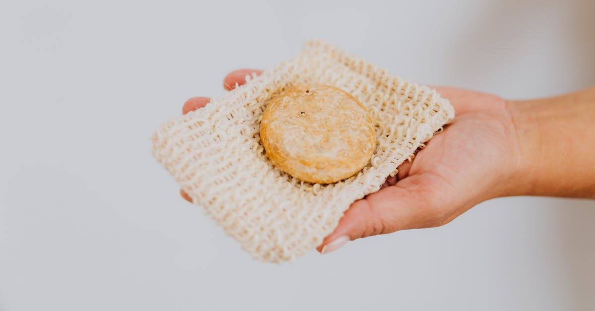 Public Shower in Mallorca [closed] - Person Holding White and Yellow Knit Textile