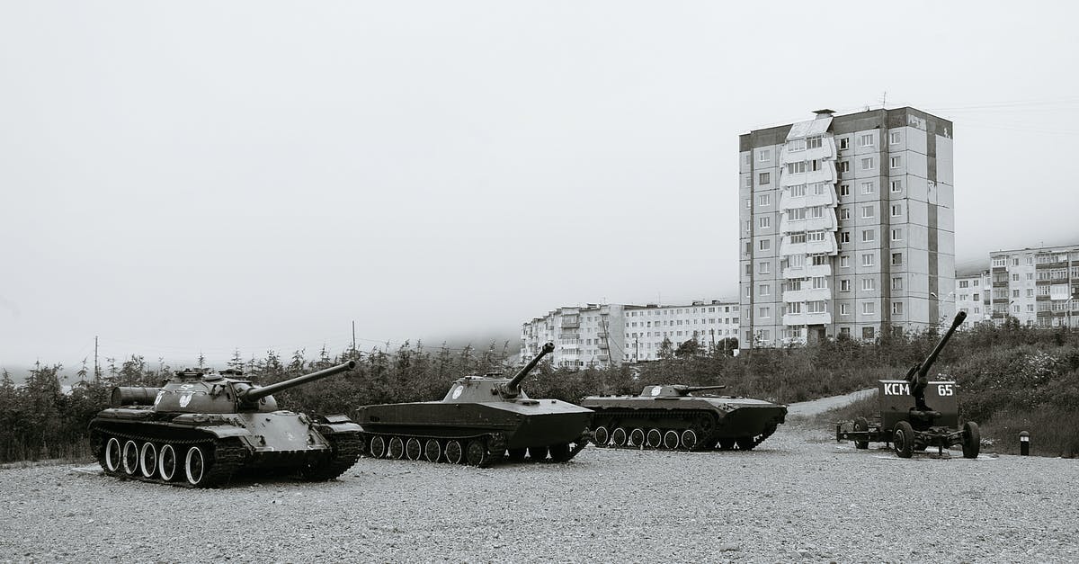 Public transport to Jotunheimen National Park - Black and white of monuments of various military vehicles on square in city